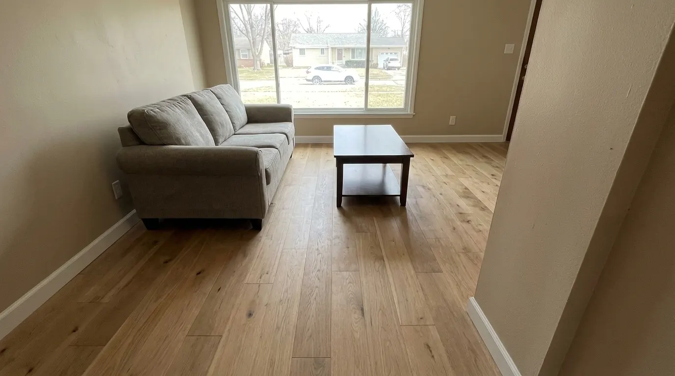Same living room with new premium plank flooring and repaired walls after restoration